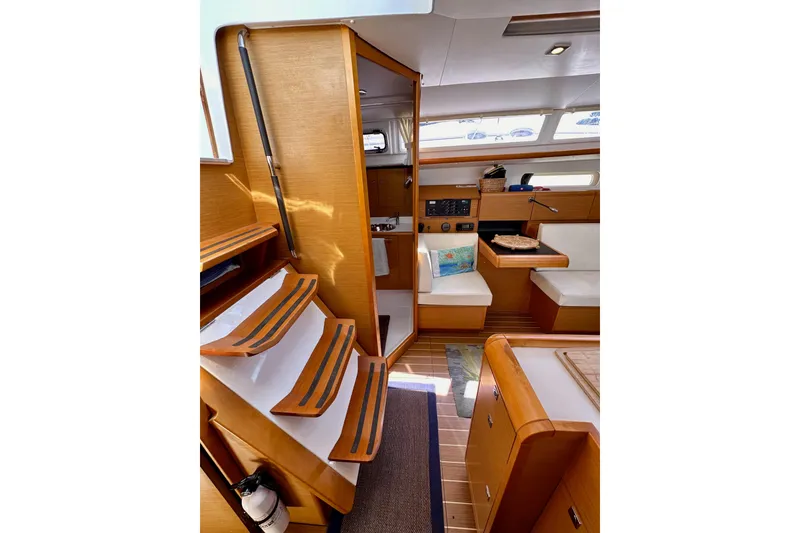 Slide: The Image of Interior of 2015 Jeanneau Sun Odyssey 409 sailboat, featuring wooden finishes and seating area. - 52