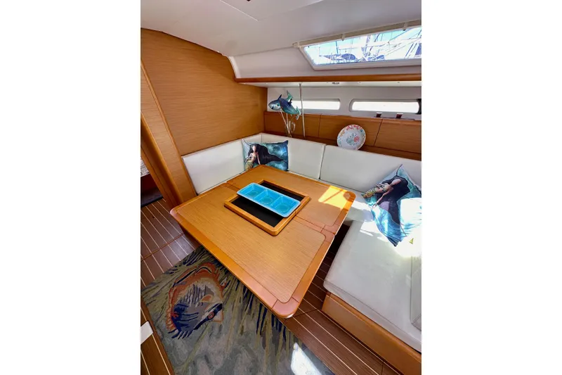 Slide: The Image of Cozy interior of 2015 Jeanneau Sun Odyssey 409 sailboat with wooden table and cushions. - 63