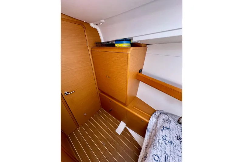 Slide: The Image of Interior cabin of 2015 Jeanneau Sun Odyssey 409 sailboat, featuring wooden cabinetry and nautical decor. - 68
