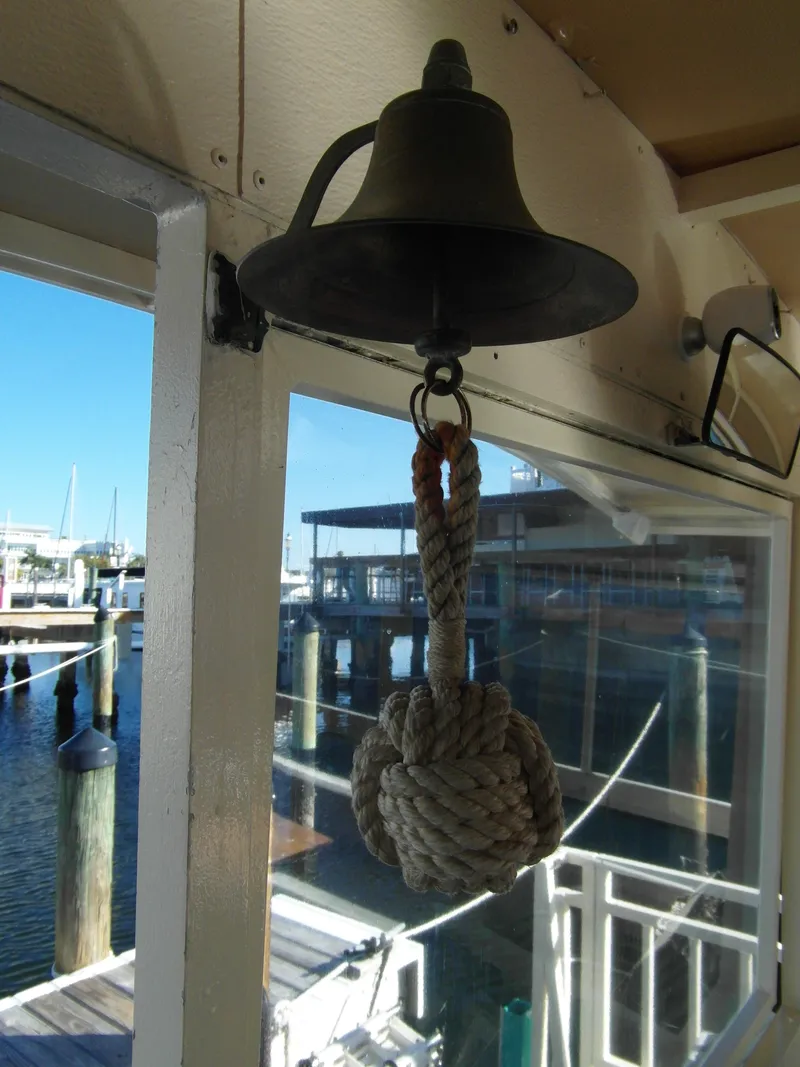 Slide: The Image of Bell with rope knot on 2005 Trident 40 Passenger Tour Boat, dockside view. - 22