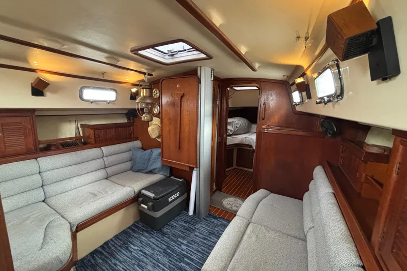 Slide: The Image of Interior of 1995 Island Packet 37 sailboat with cozy seating and wooden accents. - 20