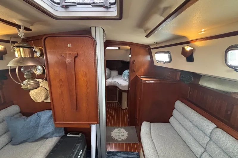 Slide: The Image of Interior of 1995 Island Packet 37 sailboat with cozy seating and wooden finishes. - 21