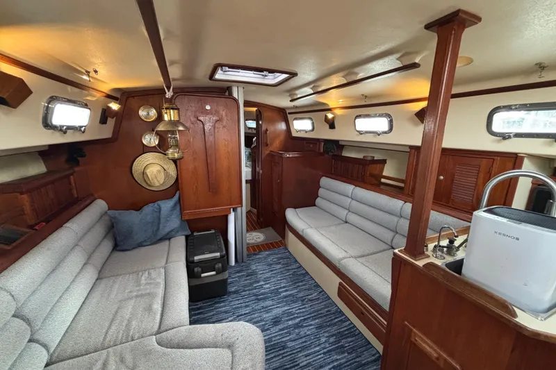 Slide: The Image of Interior of 1995 Island Packet 37 sailboat with cozy seating and wooden accents. - 22