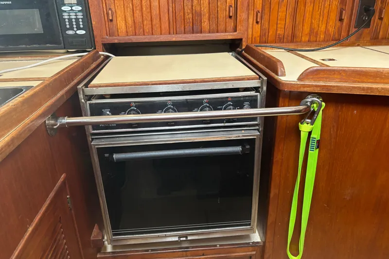 Slide: The Image of 1995 Island Packet 37 yacht kitchen with stove and wooden cabinetry. - 26