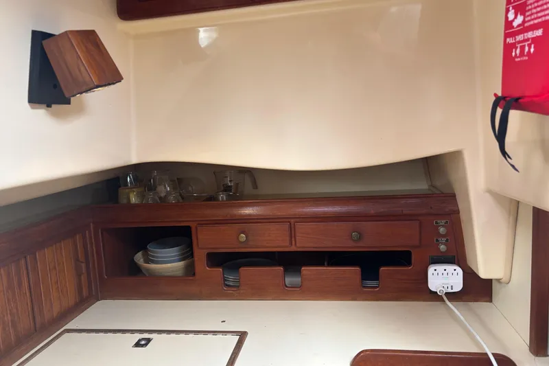 Slide: The Image of Interior of 1995 Island Packet 37 sailboat with wooden cabinetry and storage. - 28