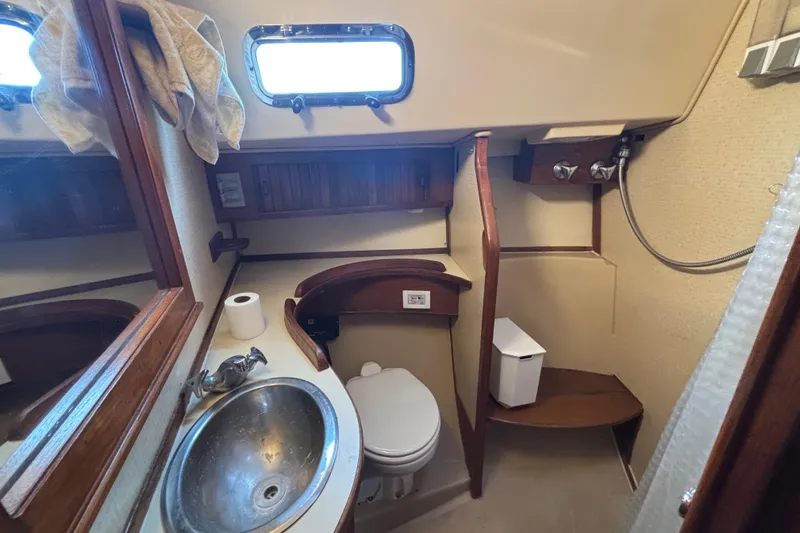 Slide: The Image of 1995 Island Packet 37 yacht bathroom with sink, toilet, and wooden accents. - 29
