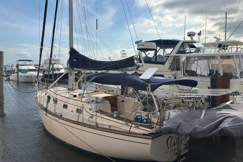 Slide: The Image of 1995 Island Packet 37 sailboat docked at a marina, surrounded by other boats. - 30