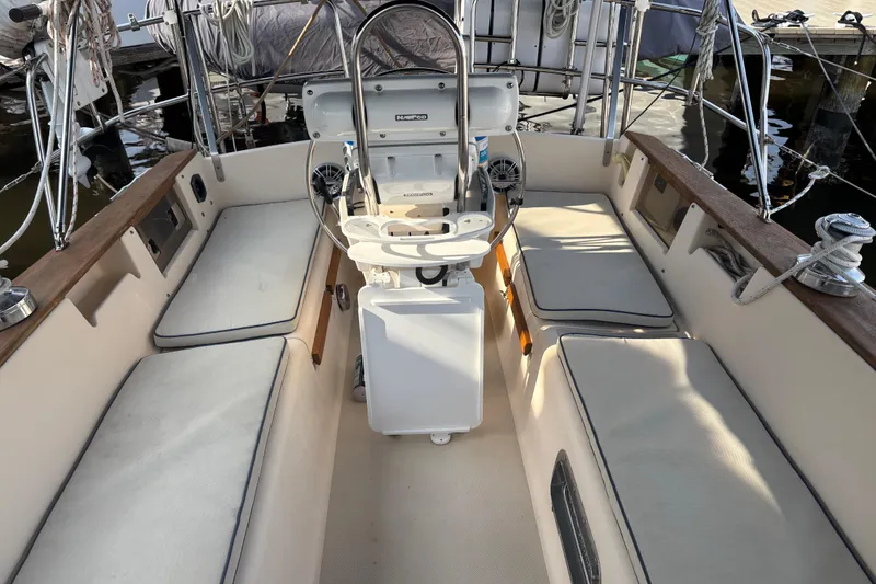 Slide: The Image of 1995 Island Packet 37 sailboat cockpit with cushioned seating and steering wheel. - 5