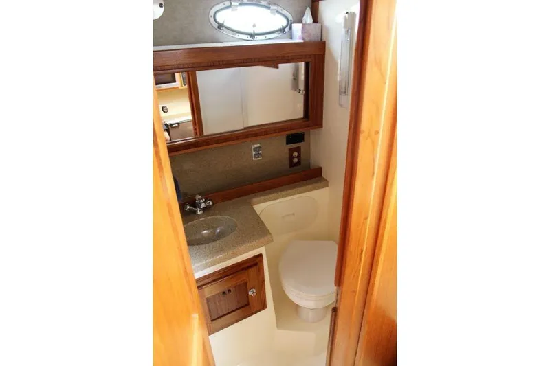 Slide: The Image of 2005 Albemarle 280 Express Fisherman boat bathroom with sink, mirror, and toilet. - 12