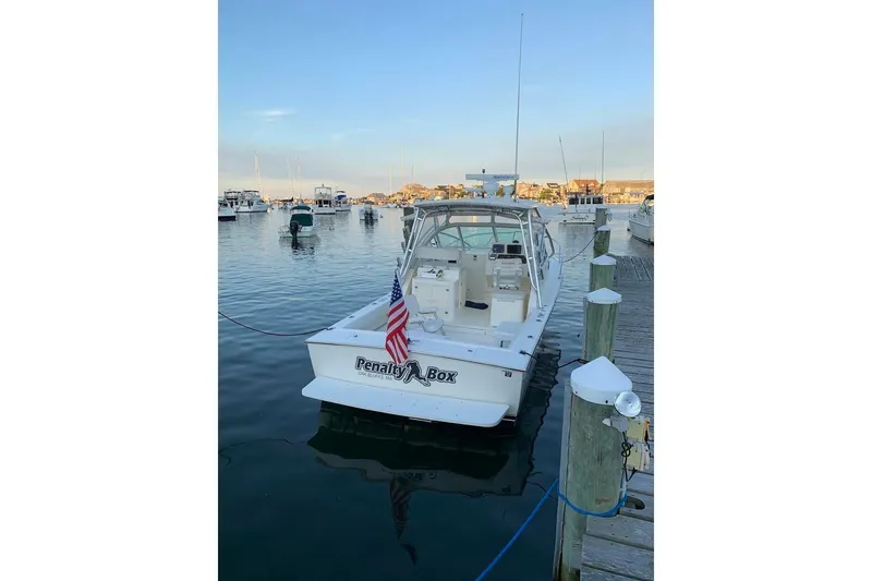 Slide: The Image of 2005 Albemarle 280 Express Fisherman boat docked in a marina, displaying an American flag. - 2