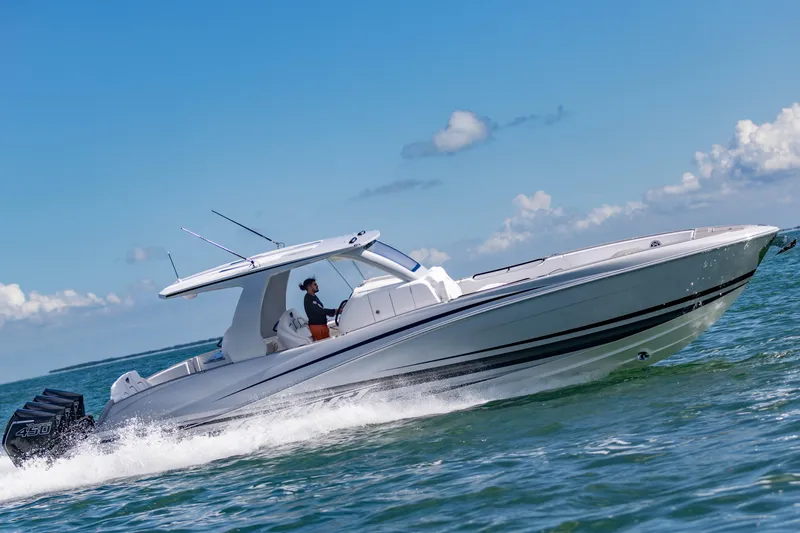 Slide: The Image of 2024 Deep Impact 399 Sport boat cruising on open water under a clear blue sky. - 11