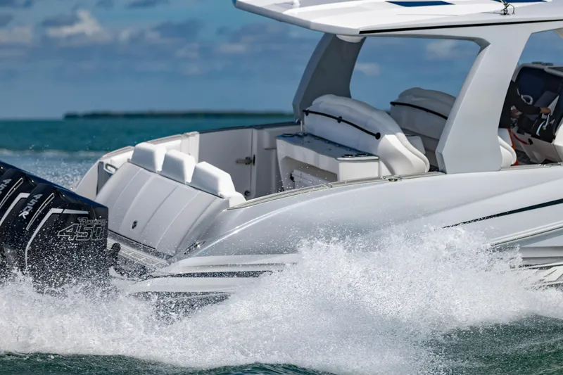 Slide: The Image of 2024 Deep Impact 399 Sport boat cruising on water, showcasing powerful engines and sleek design. - 14