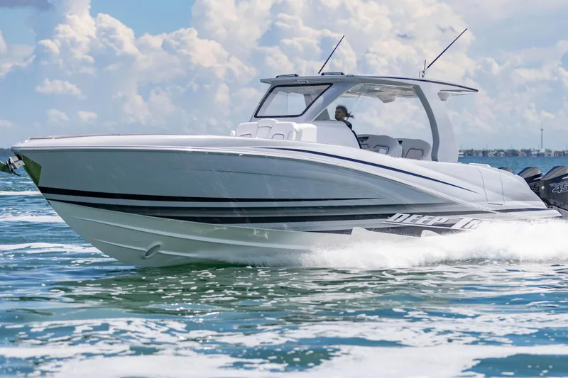 Slide: The Image of 2024 Deep Impact 399 Sport boat cruising on open water under a cloudy sky. - 21