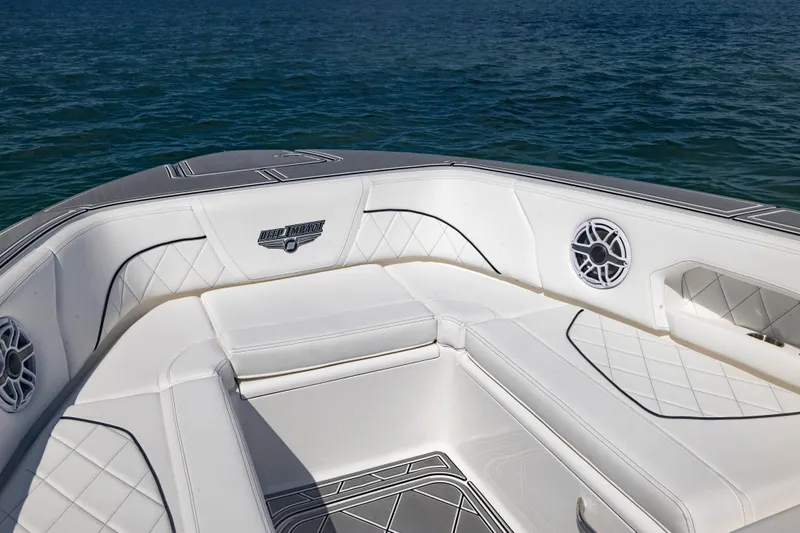 Slide: The Image of 2024 Deep Impact 399 Sport boat interior with white seating and ocean backdrop. - 23