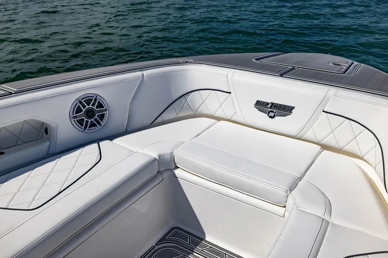 Slide: The Image of 2024 Deep Impact 399 Sport boat interior with white seating and speaker detail. - 24