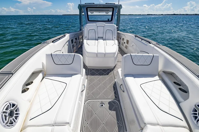 Slide: The Image of 2024 Deep Impact 399 Sport boat interior with luxurious white seating and ocean view. - 27