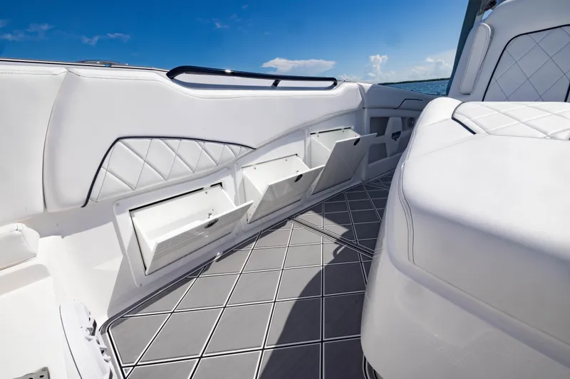 Slide: The Image of 2024 Deep Impact 399 Sport boat interior with white seating and storage compartments. - 29