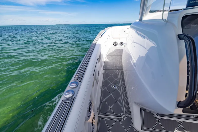 Slide: The Image of 2024 Deep Impact 399 Sport boat on clear ocean water, showcasing sleek design and deck details. - 33