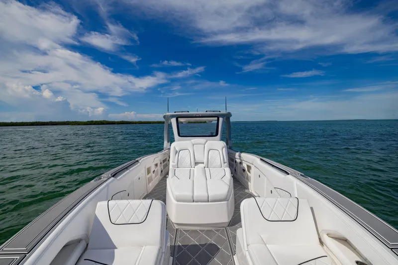 Slide: The Image of 2024 Deep Impact 399 Sport boat on open water under a clear blue sky. - 34