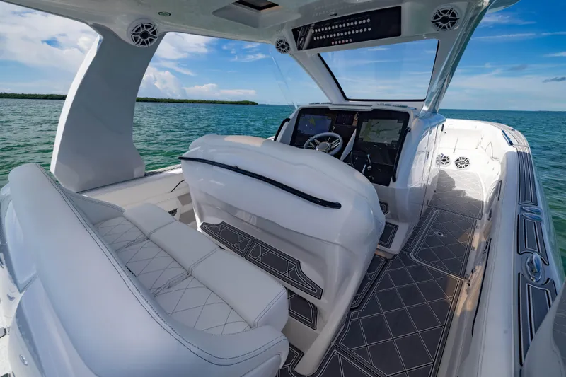 Slide: The Image of 2024 Deep Impact 399 Sport boat interior with modern dashboard and luxurious seating on open water. - 41