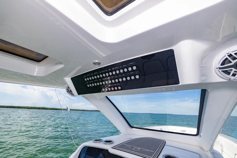 Slide: The Image of 2024 Deep Impact 399 Sport boat interior with control panel and ocean view. - 42