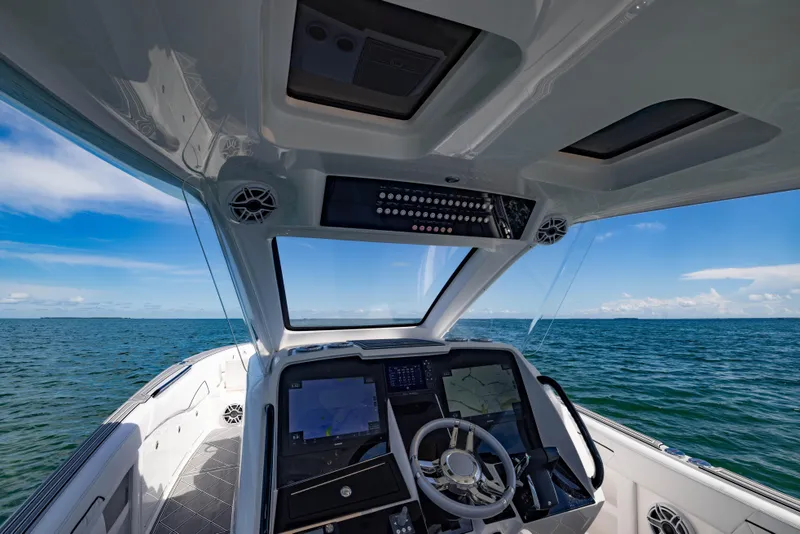 Slide: The Image of 2024 Deep Impact 399 Sport boat cockpit with ocean view, featuring advanced navigation systems. - 59