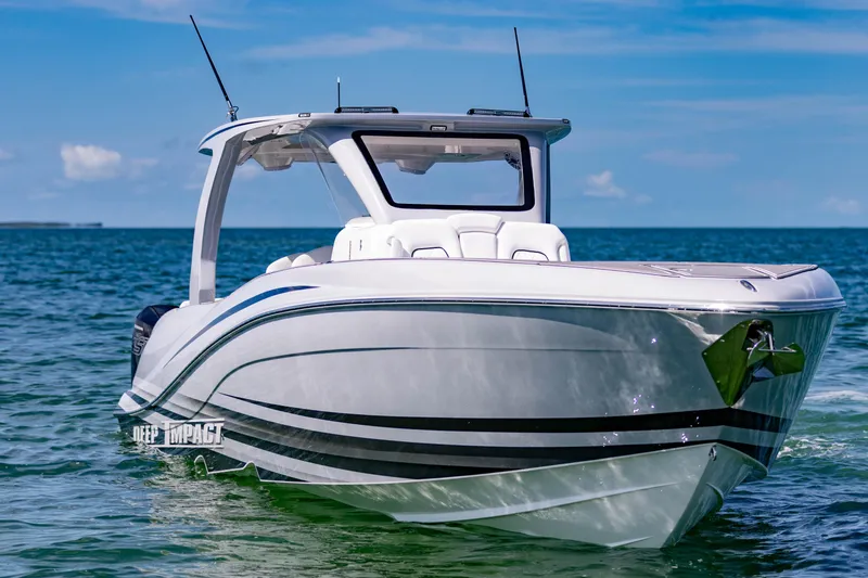 Slide: The Image of 2024 Deep Impact 399 Sport boat on clear blue water under a sunny sky. - 6