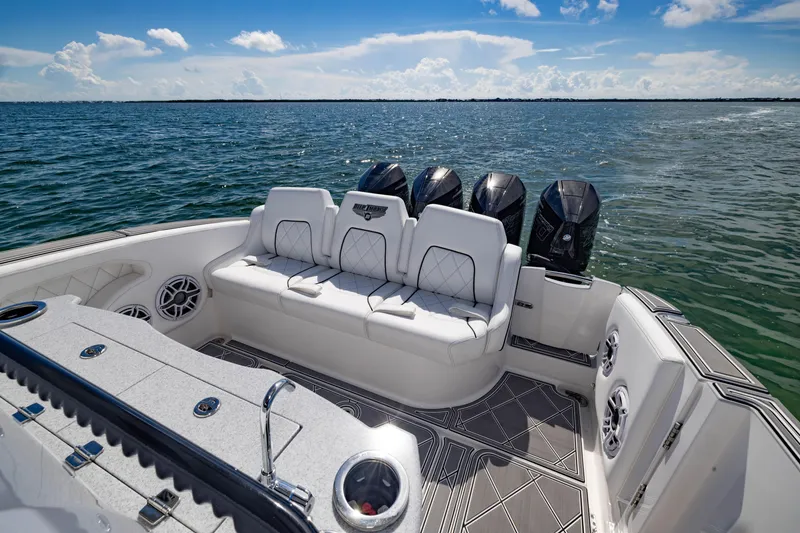 Slide: The Image of 2024 Deep Impact 399 Sport boat interior with luxurious seating and multiple outboard engines. - 60