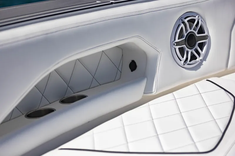 Slide: The Image of 2024 Deep Impact 399 Sport boat interior with white quilted seating and speaker detail. - 67