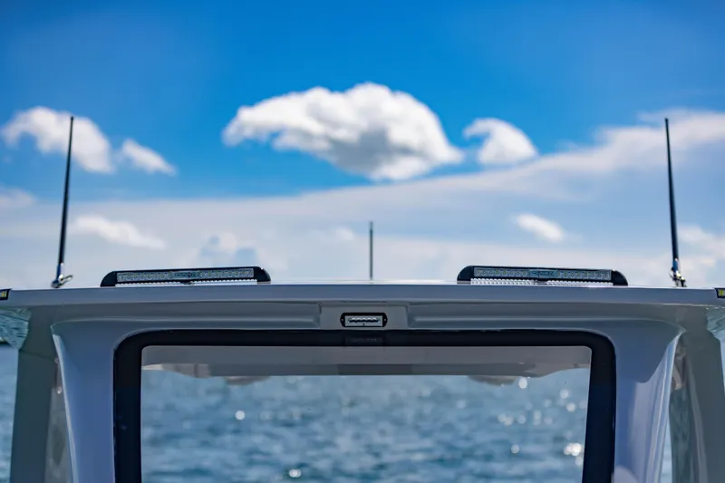 Slide: The Image of 2024 Deep Impact 399 Sport boat against a clear blue sky and ocean backdrop. - 68