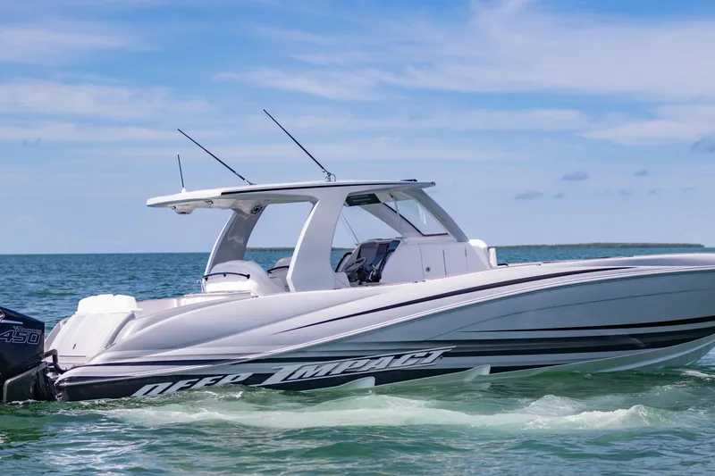 Slide: The Image of 2024 Deep Impact 399 Sport boat cruising on open water under a clear blue sky. - 8