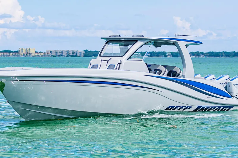 Slide: The Image of 2023 Deep Impact 399 Sport boat cruising on clear turquoise water. - 13