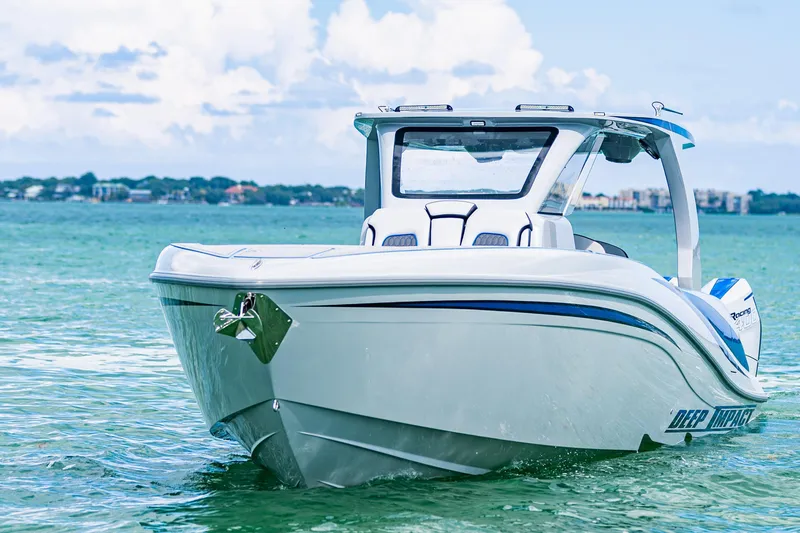 Slide: The Image of 2023 Deep Impact 399 Sport boat on clear blue water, showcasing sleek design. - 14