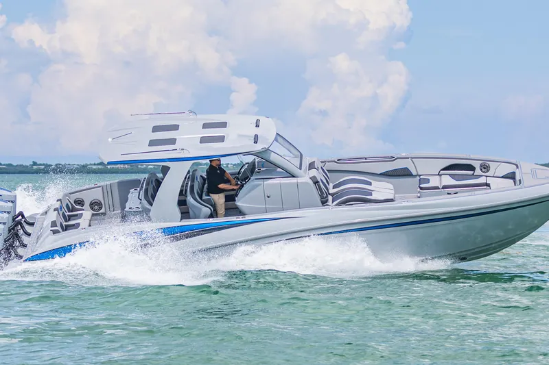 Slide: The Image of 2023 Deep Impact 399 Sport boat cruising on clear water under a blue sky. - 19