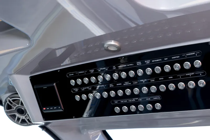 Slide: The Image of Control panel of 2023 Deep Impact 399 Sport boat with multiple switches and speaker. - 21