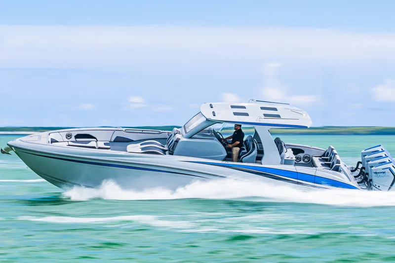 Slide: The Image of 2023 Deep Impact 399 Sport boat cruising on clear blue water. - 4