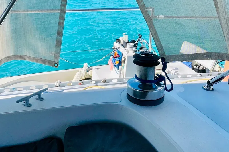 Slide: The Image of 1986 Gulfstar HIRSCH sailboat deck with winch, overlooking clear blue water. - 12