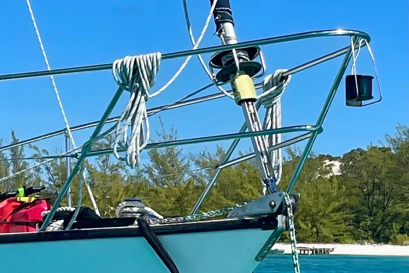 Slide: The Image of 1986 Gulfstar HIRSCH sailboat bow with ropes, anchored near a tropical shoreline. - 20