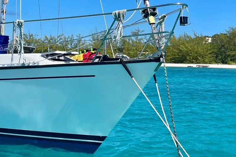 Slide: The Image of 1986 Gulfstar HIRSCH sailboat anchored in clear turquoise water near a sandy beach. - 21