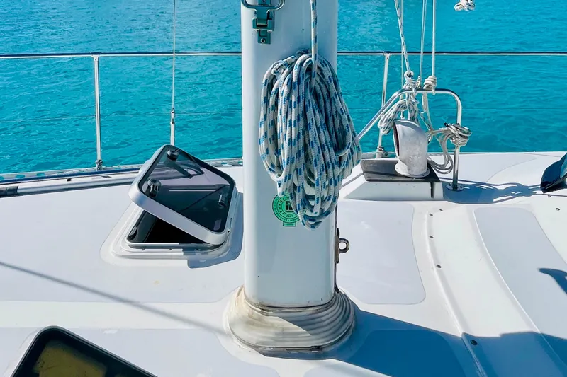 Slide: The Image of Sailboat deck of 1986 Gulfstar HIRSCH with open hatch and coiled rope, turquoise water background. - 25