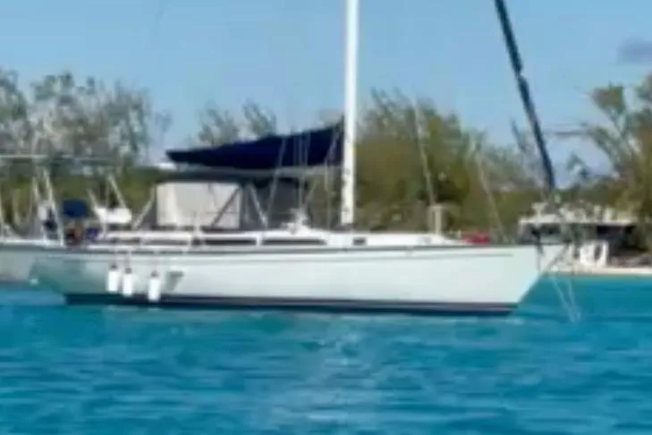Slide: The Image of 1986 Gulfstar HIRSCH sailboat on turquoise water, with trees in the background. - 64