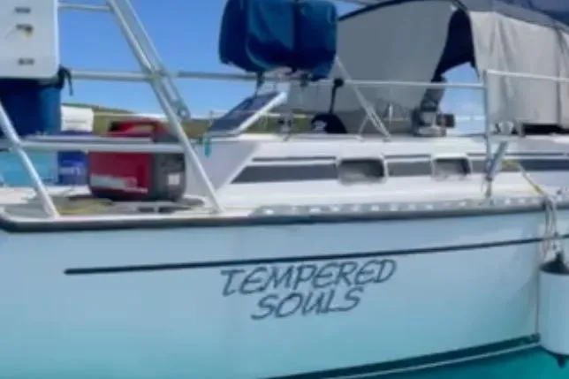 Slide: The Image of 1986 Gulfstar HIRSCH sailboat named "Tempered Souls" docked in clear blue water. - 68