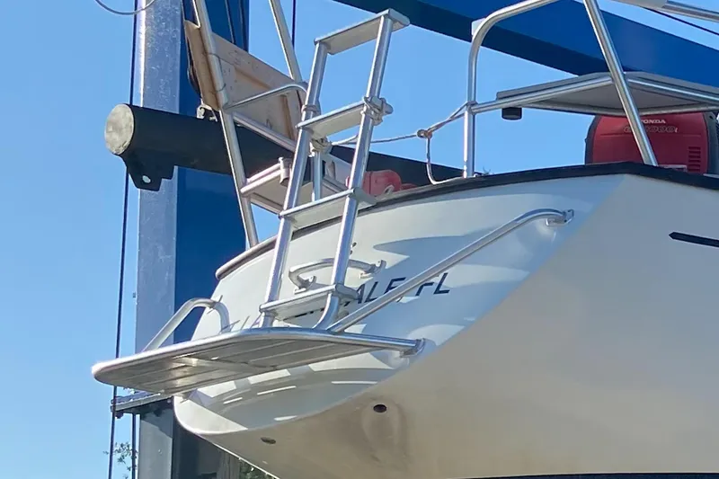 Slide: The Image of 1986 Gulfstar Hirsch 45 sailboat stern with ladder and railing under clear blue sky. - 69