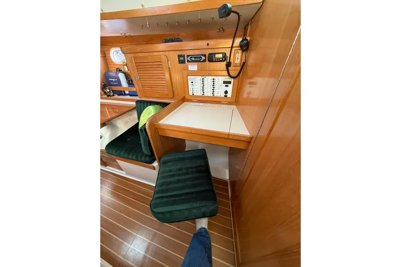 Slide: The Image of Navigation station inside 2004 Catalina 36 MkII sailboat with wood paneling and green seating. - 11