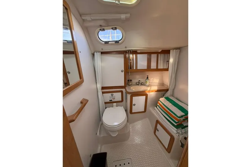 Slide: The Image of Bathroom interior of 2004 Catalina 36 MkII yacht, featuring toilet, sink, and storage. - 17