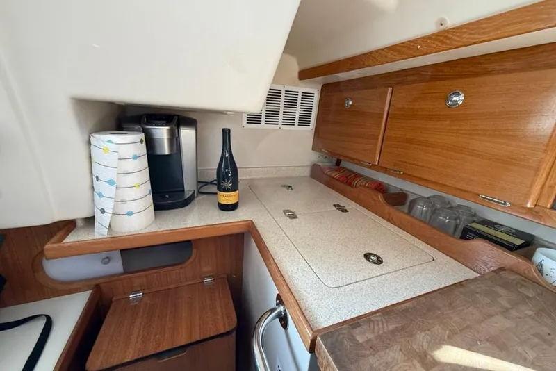 Slide: The Image of 2004 Catalina 36 MkII yacht kitchen with wooden cabinets, countertop, and appliances. - 22