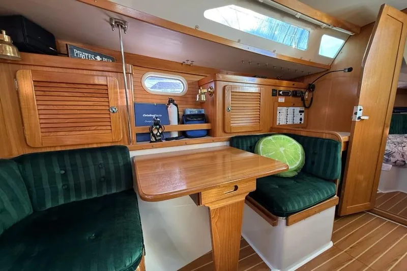 Slide: The Image of 2004 Catalina 36 MkII yacht interior with wooden cabinetry and green cushioned seating. - 7