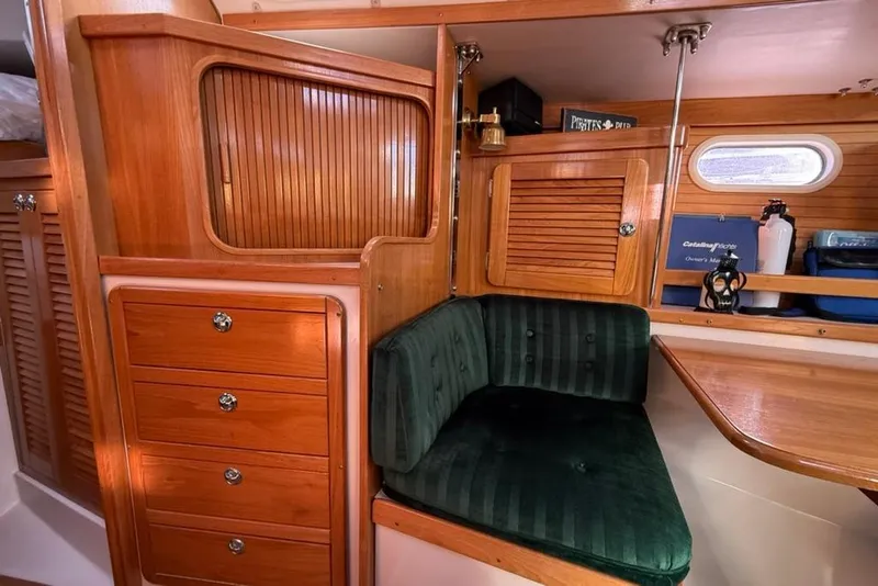 Slide: The Image of Interior of 2004 Catalina 36 MkII sailboat with wooden cabinetry and green cushioned seating. - 9
