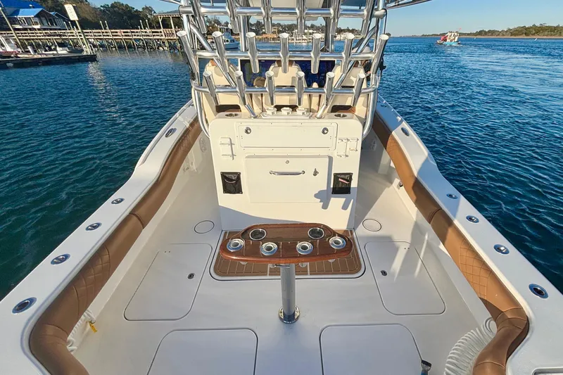 Slide: The Image of 2022 Tideline 365 Offshore boat interior with rod holders, on calm water. - 19