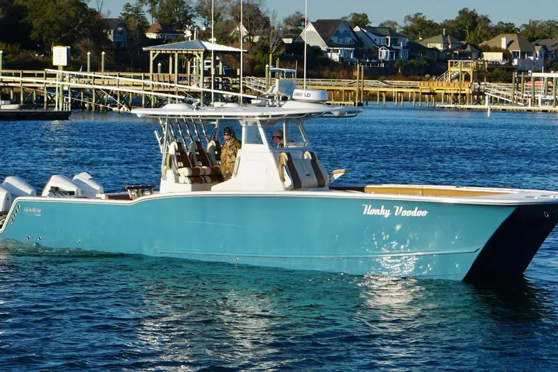 Slide: The Image of 2022 Tideline 365 Offshore boat on calm water, featuring triple Mercury engines. - 2